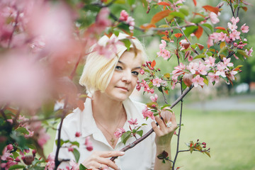 portrait of a beautiful blonde with short hair among flowers