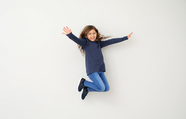 Jumping little girl on white background