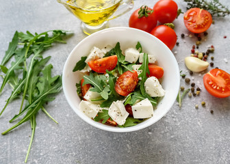 Italian cuisine. Vegetarian food. Salad with mozzarella, arugula and cherry tomatoes.