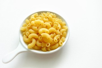 Macaroni on white bowl and white background. 