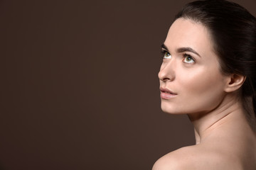 Fototapeta premium Young woman with beautiful eyebrows on color background