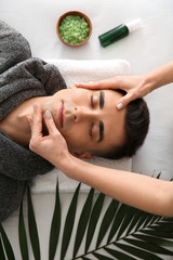 Man receiving face massage in beauty salon