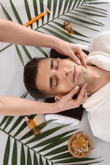 Man receiving face massage in beauty salon