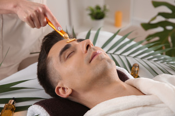 Man receiving face massage in beauty salon