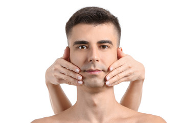 Handsome man receiving face massage on white background