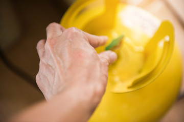 Closeup of a hand opening refrigerant tank equipment for filling air conditioners.