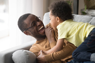 Fototapeta premium Happy african dad laughing playing with little toddler son together