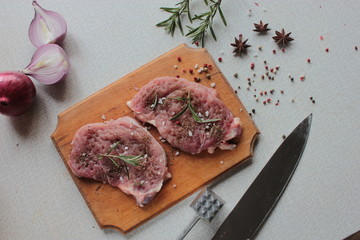 Fresh raw meat with spices on a wooden board.