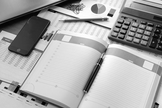 Open leather notebook, drawings, charts, phone, calculator, pencil and laptop on the desk in the office. Business and Finance.