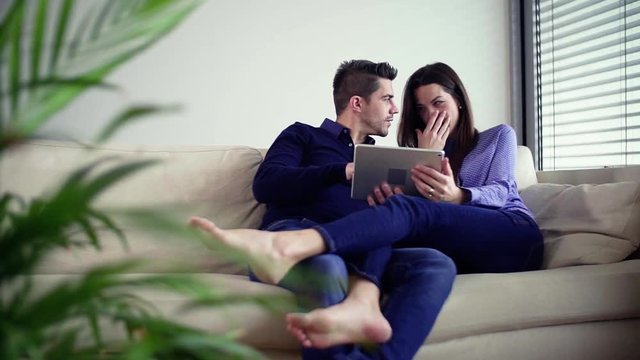 Young couple with tablet moving in a new home, planning how to decorate it.