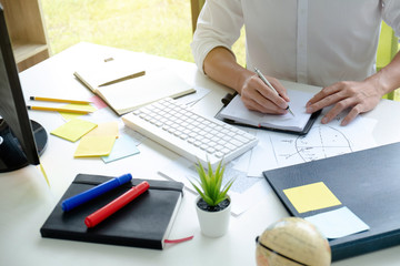 man college student taking notes for research or doing home work at home