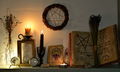Open magic book with spells, tarot cards, crystals, candles and pentagram. Magic gothic ritual....