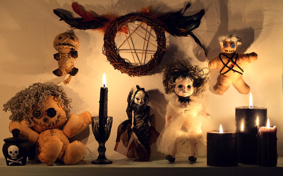 Scary voodoo dolls, pentagram and black candles. Magic gothic ritual. Wicca, esoteric, divination and occult background with vintage objects