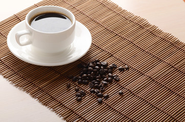 white cup of coffee on a bamboo napkin