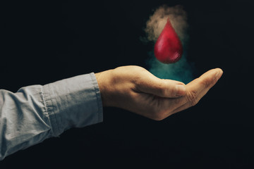 Human hand blood drop. Nebula dust in infinite space. World Blood Donor Day. Mixed media.