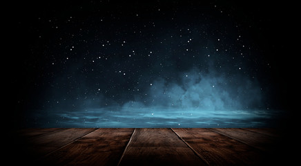 Dark empty room with brick walls and neon lights, smoke, rays. Brick wall, concrete and wooden table. © MiaStendal