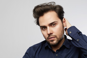 Handsome hispanic trendy man posing isolated on a white empty background and looking camera.