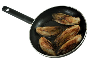 Endives braisées dans une poêle sur fond blanc 