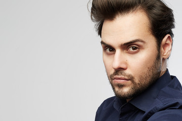 Handsome hispanic trendy man posing isolated on a white empty background and looking camera.