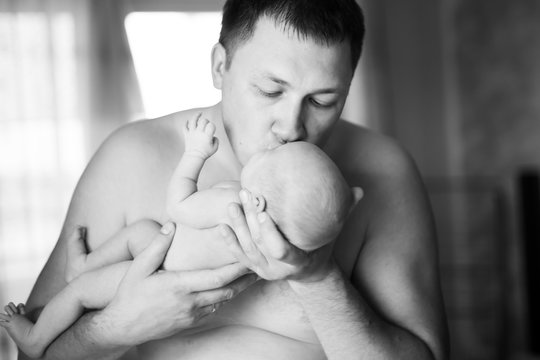 happy father kissing his newborn daughter. photo in retro style