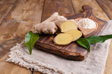 fresh ginger with leaves on wooden background. Food for health and beauty. Free space for text. Copy space.