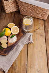 Obraz na płótnie Canvas ginger, lemon and glass on a wooden background, Photo in rustic style. Ingredients for warming and health drink. Alternative medicine. Free space for text.