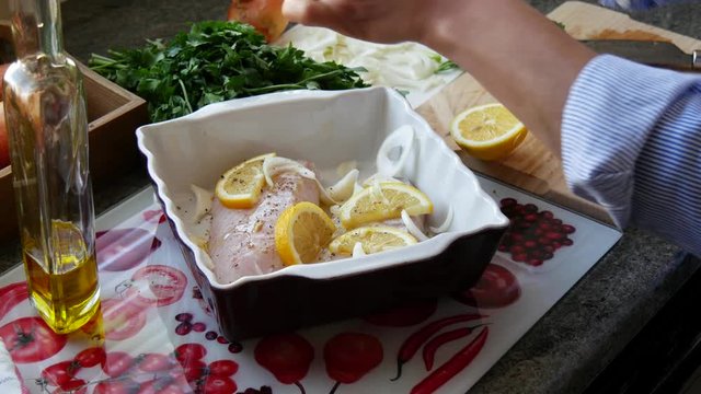 preparation of fresh fish, raw cod fillets with addition of herbs and lemon