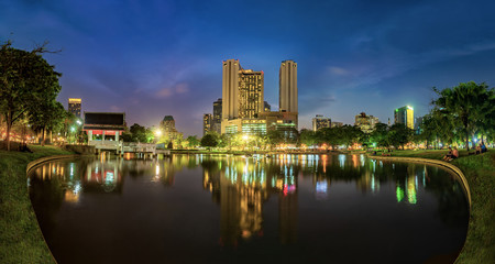 Bangkok business district with the public park area in the foreground at sunset time