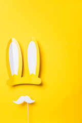 Yellow easter bunny ears with white moustache. Seasonal lay flat backgroud