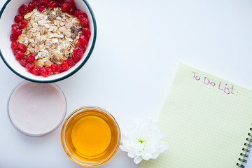 Planning concept. Muesli, fruits and notebook  on a bright background. Space for a text. Top view.