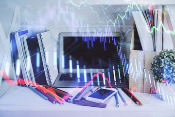 Double exposure of stock market chart and office desktop on background. financial strategy concept.
