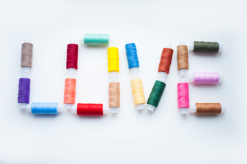 Spool of colorful threads on the white background. Top view. Space for your text.