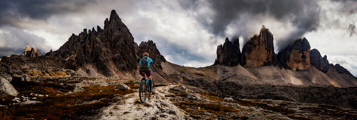 Cycling woman  riding on bike in Dolomites mountains landscape. Girl cycling MTB enduro trail track. Outdoor sport activity.