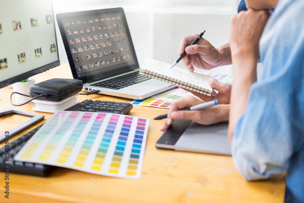 Aufkleber graphic designer team working on web design using color swatches editing artwork using tablet and a 