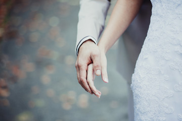 Brautpaar halten sich an den Händen