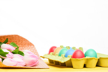 Egg hunt. Spring holiday. Holiday celebration, preparation. Tulip flower bouquet. Healthy and happy holiday. painted eggs in egg tray. Happy easter. copy space. Easter preparations