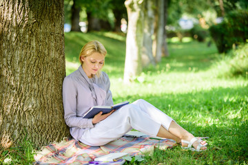 Naklejka na ściany i meble Books every girl should read. Relax leisure an hobby concept. Best self help books for women. Girl concentrated sit park lean tree trunk read book. Reading inspiring books. Bestseller top list