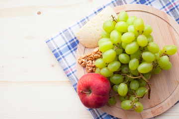 Healthy food concept. Fresh organic fruits and nuts on the wooden cutting board. Close up. Top view.