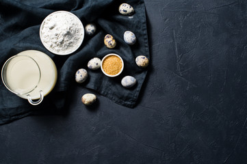 The concept of cooking gluten-free and lactose-free baking. Ingredients: bananas, quail eggs, sugar, gluten free flour, oat milk. Black background, top view, space for text
