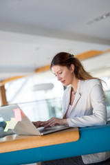 Attractive young female architect working on laptop