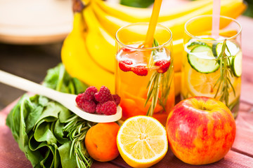 Fresh detox juices in glass bottles on the wooden background. Fruits and berries. Lifestyle, vegan food and drink, health care, diet and summer concept. Top view. Close up.
