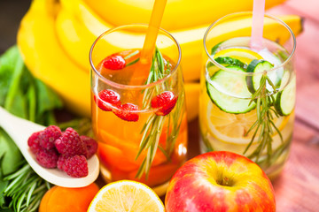 Fresh detox juices in glass bottles on the wooden background. Fruits and berries. Lifestyle, vegan food and drink, health care, diet and summer concept. Top view. Close up.