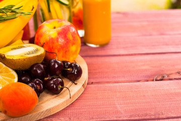 Fresh detox juices in glass bottles on the wooden background. Fruits and berries. Lifestyle, vegan food and drink, health care, diet and summer concept. Top view. Close up.