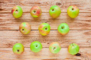 Fresh raw apples and clay pot with berries on the vintage wooden background. Autumn, healthy food, ingredients and holiday concept. Top view. Close up.