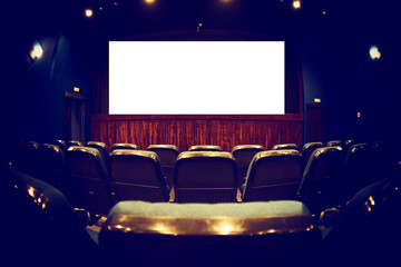 Empty cinema auditorium with empty white screen. Empty rows of theater or movie seats. Toned.