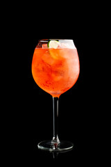 Rum based red cocktail with lime in wine glass isolated on black background. Selective focus. Shallow depth of field. 