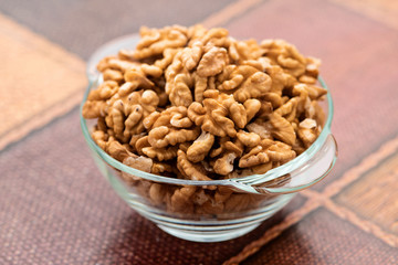 Studio photo of bowl with heap of peeled walnuts