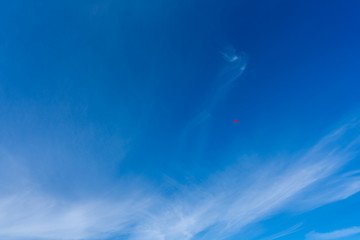 Blue sky with paraglider at high altitude.