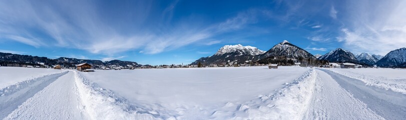 Sunny snow covered landscape near Oberstdorf, Bavaria, Germany. Panorama with hiking trail.