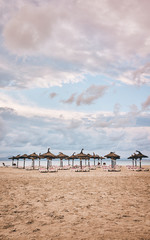 Beach with umbrellas and sunbeds, color toned picture.